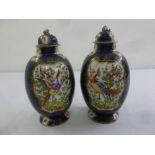 A pair of Oriental ovoid vases and covers decorated with birds and flowers
