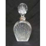 A cut glass shaped oval decanter with white metal collar and drop stopper