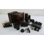 A quantity of camera accessories to include lenses, a bellows camera and light meters