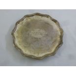 A silver presentation salver, shaped circular on three volute scroll legs, Sheffield 1929