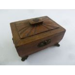 A Regency leather sarcophagus shaped work box with brass mounts on four paw feet