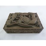 An Oriental 19th century rectangular cigar box, carved in deep relief with dragons and vegetation
