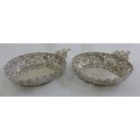 A pair of late Victorian silver bonbon dishes, circular scroll pierced sides with leaf handles,