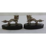 A pair Chinese white metal dragons on oval hardwood stands
