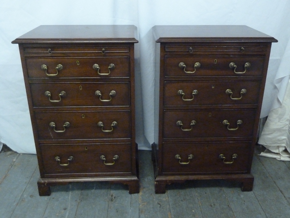 A pair of rectangular mahogany bedside chests with brass swing handles on four bracket feet