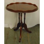 A circular mahogany side table on triform base