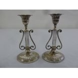 A pair of silver lyre form table candlesticks on fluted oval bases, London 1901