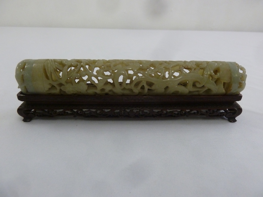 A Chinese cylindrical jade scroll holder carved and pierced with prunus blossom and leaves with