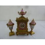 A French 19th century ormolu and porcelain clock set, two train movement with Roman numerals, the
