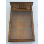 A wooden shaped rectangular glazed wall mounted cabinet