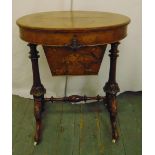 A Victorian oval sewing table on carved scrolling legs