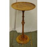 A walnut circular wine table on turned cylindrical stem and raised circular base