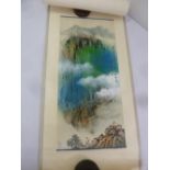 A Chinese scroll painting of a landscape in the clouds, signed to the right hand side