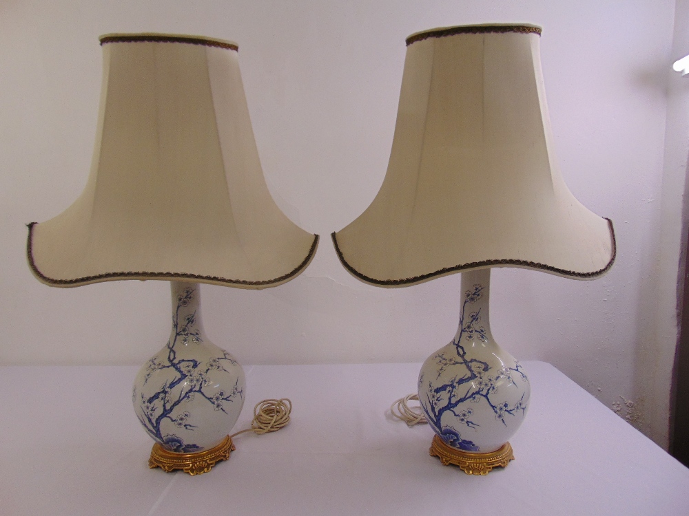 A pair of Porcelain de Paris table lamps with silk shades