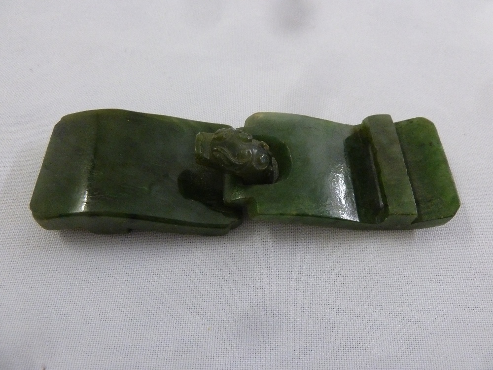 A Chinese green polished jade two part belt buckle with dragon head clasp