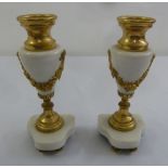 A pair of gilt metal and white marble garnitures on shaped oval marble bases