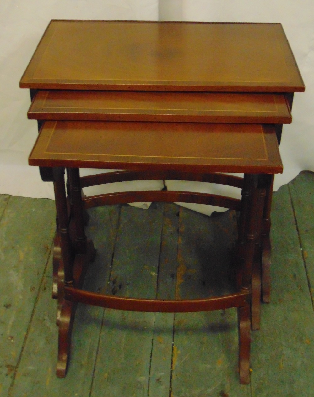 A mahogany nest of three rectangular tables