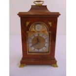 An 18th century style walnut bracket clock with silvered dial and Roman numerals with brass carrying