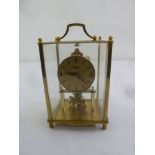 Kundo four glass and gilt metal mantle clock with revolving pendulum