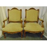 A pair of French style mahogany upholstered armchairs on four scroll legs