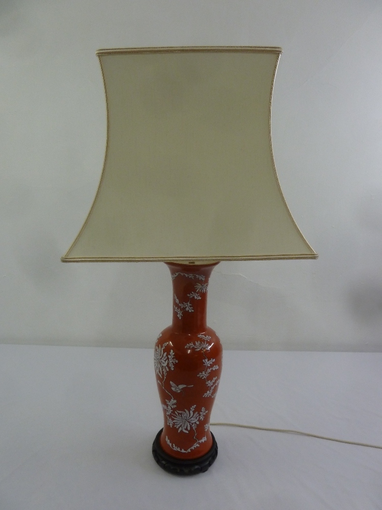 A Chinese baluster form red ground table lamp and silk shade