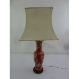 A Chinese baluster form red ground table lamp and silk shade