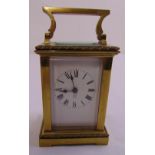 A French brass carriage clock of customary form with Roman numerals and enamel dial