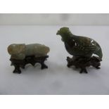 A Chinese jade carving of a dragon on hardwood stand and a green hardstone carving of a bird on