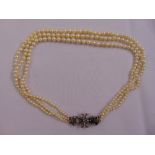 A three strand cultured pearl graduated necklace with a Victorian silver diamond and sapphire clasp