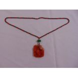 A Chinese carved pendant on a semi-precious beaded necklace