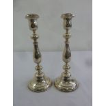 A pair of silver hallmarked filled table candlesticks of baluster form on raised circular bases