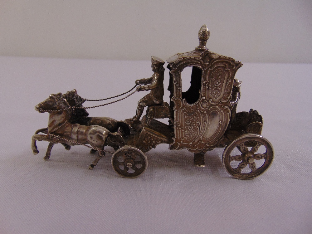 A continental white metal model of a horse drawn carriage, marks to base