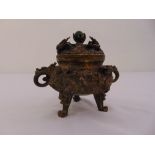 An Oriental brass incense burner profusely carved with dragons and domed pull off cover, two side