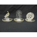 Three Lalique circular glass pin trays, marks to the bases