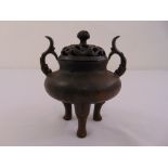 A Chinese bronze incense burner of compressed cylindrical form with domed and pierced pull off cover