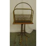 A brass and mahogany magazine rack on three outswept legs