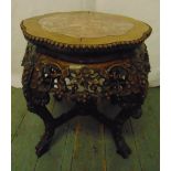 A Chinese hardwood side table, barrel form, profusely carved with flowers, leaves and berries, inset