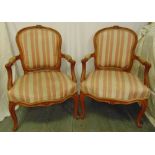 A pair of French style mahogany upholstered armchairs on cabriole legs