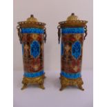 A pair of French enamelled cylindrical lamp bases with gilt metal mounts on four lion mask scroll