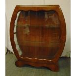 An Art Deco glazed display cabinet with glass shelves on shaped scroll base