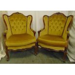 A pair of mahogany wingback armchairs on scroll feet