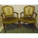 A pair of mahogany upholstered armchairs on cabriole legs