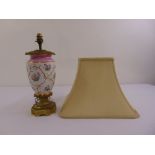 A gilt metal and porcelain table lamp, ovoid form on hexagonal base with silk shade