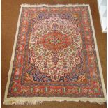 A Persian wool carpet red and cream ground, central floral medallion with repeating floral pattern