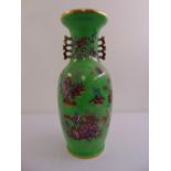 An Oriental green glazed baluster vase decorated with pagodas, flowers and leaves