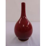 A Chinese ox blood red glazed baluster vase with elongated neck