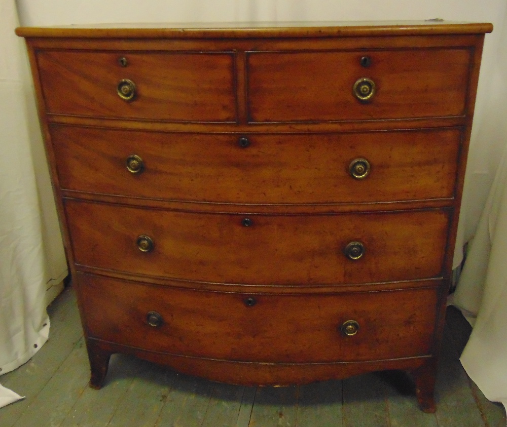 A 19th century rectangular bow fronted chest of drawers with brass swing handles on four scroll