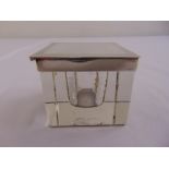 A square glass inkwell with silver engine turned cover