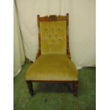 A Victorian mahogany upholstered button back chair on turned legs and original castors