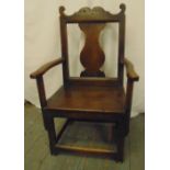 An early 18th century oak chair with central splat, open arms and canted square legs